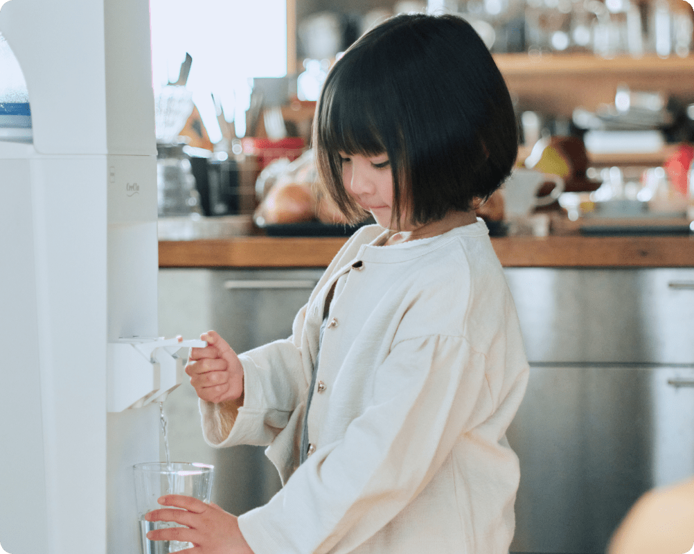 ウォーターサーバーで水を注ぐ子供