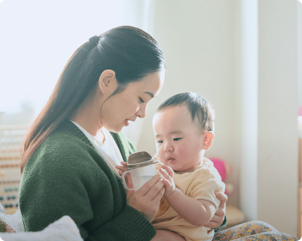 赤ちゃんに水をあげる女性