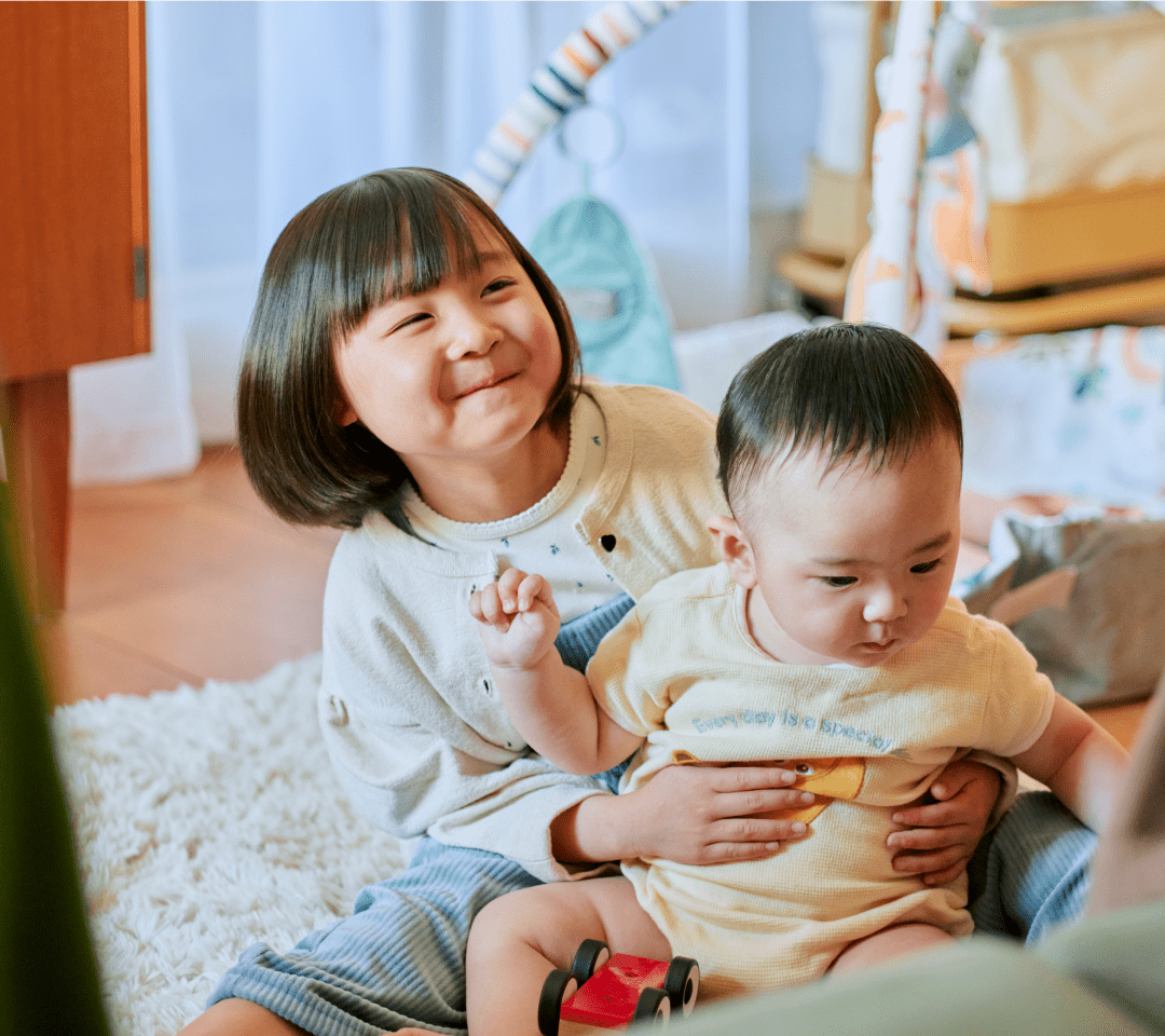 赤ちゃんを抱く子供