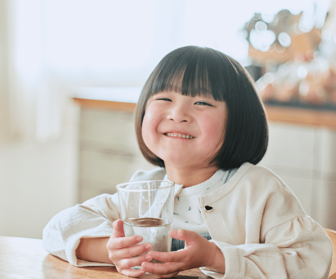 グラスに入った水を飲む子供