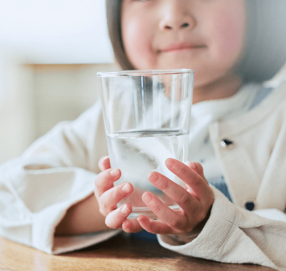 水の入ったグラスを持つ子供
